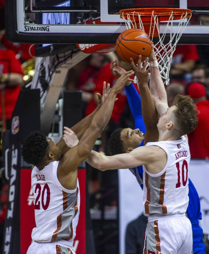 UNLV Rebels forward Nick Blair (20) and teammate guard Jonah Antonio (10) defend a shot under t ...