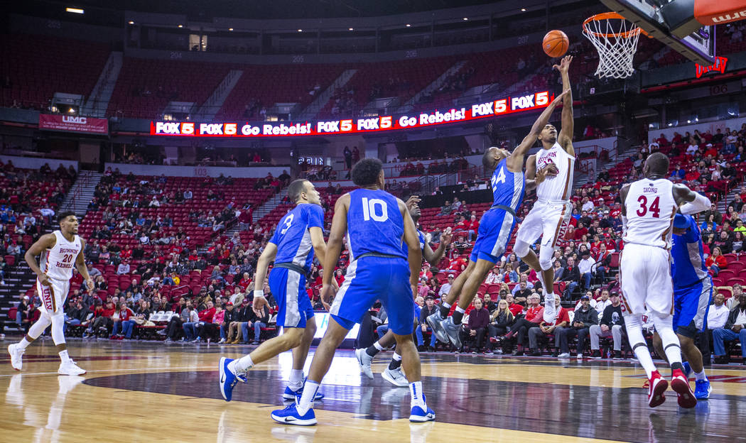 UNLV Rebels guard Bryce Hamilton (13, right) gets past Air Force Falcons guard Mason Taylor (24 ...