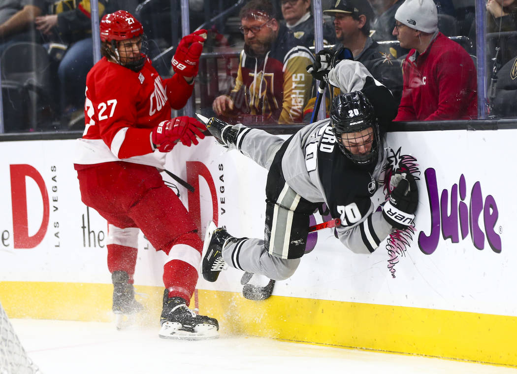 Providence Friars' Parker Ford (20) gets tripped up in front of Cornell Big Red's Morgan Barron ...