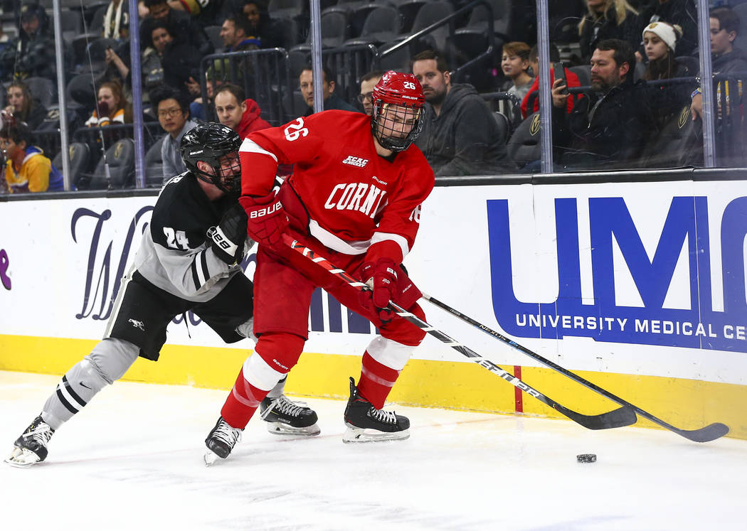 Cornell Big Red's Tristan Mullin (26) moves the puck in front of Providence Friars' Max Crozier ...