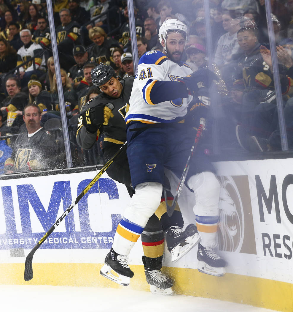 Golden Knights' Ryan Reaves (75) takes St. Louis Blues' Robert Bortuzzo (41) to the boards duri ...
