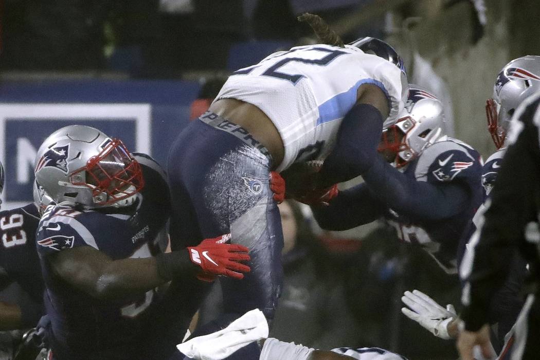 Tennessee Titans running back Derrick Henry goes over New England Patriots defenders for a touc ...
