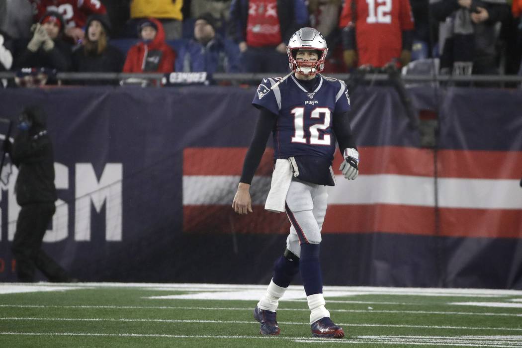 New England Patriots quarterback Tom Brady walks to the sideline after throwing an interception ...