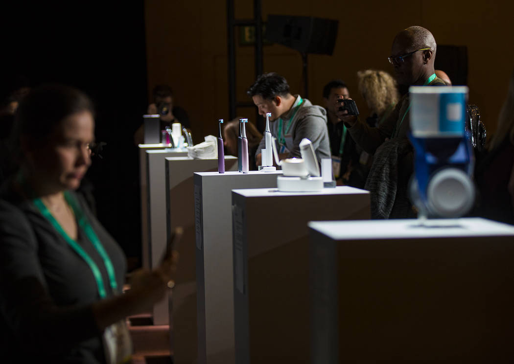 Members of the media look at products created by Procter & Gamble featured for CES at a med ...