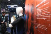 Attendees look at the E-Skin suit on display at the CES trade show at the Sands Expo Convention ...