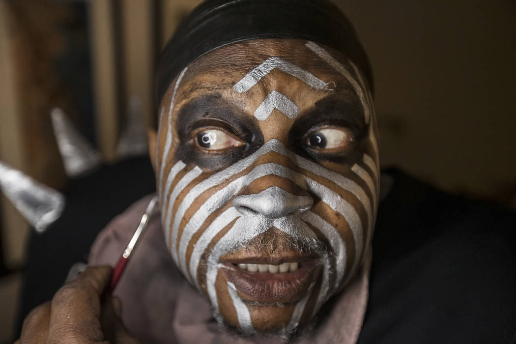 Raiders super fan Wayne Mabry, known as "Violator," applies makeup in his hotel room ...