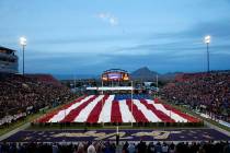Airmen from Nellis Air Force Base unfurl an American flag in pregame ceremonies before the Las ...