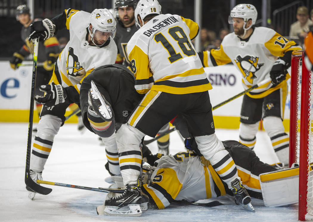 Pittsburgh Penguins goaltender Tristan Jarry (35) dives on the puck in traffic with the Vegas G ...