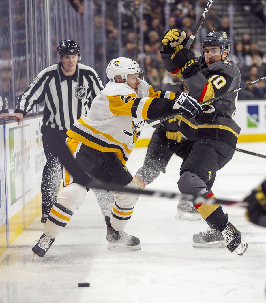 Pittsburgh Penguins' Chad Ruhwedel (2) checks Vegas Golden Knights' Nicolas Roy (10) during the ...