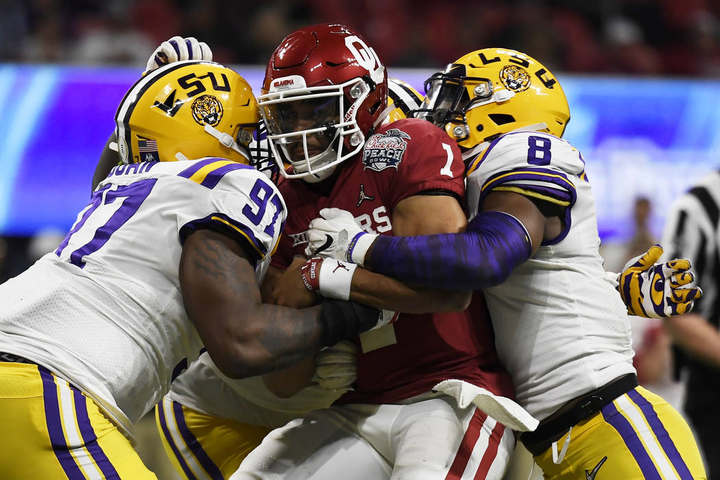 LSU linebacker Patrick Queen (8) and LSU defensive end Glen Logan (97) hits Oklahoma quarterbac ...