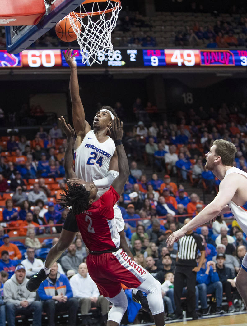 Boise State forward Abu Kigab drives, scores and draws a foul by UNLV forward Donnie Tillman du ...