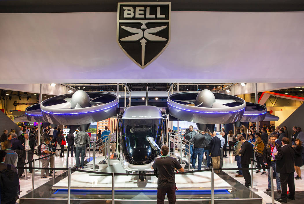 A worker dusts the front windshield of the new Bell Nexus 4EX air taxi concept on display in No ...