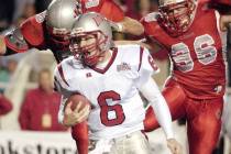 UNLV quarterback Scott Turner, center, runs from leaping New Mexico defenders Nick Speegle, lef ...