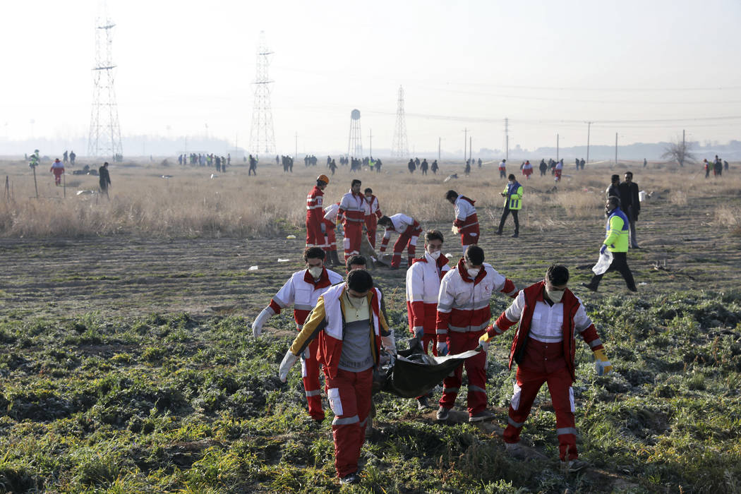 Rescue workers recover the bodies of victims of a Ukrainian plane crash in Shahedshahr, southwe ...