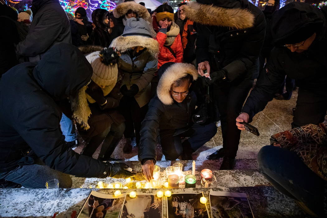 Mourners place candles and photographs outside the Alberta Legislature Building in Edmonton, Al ...
