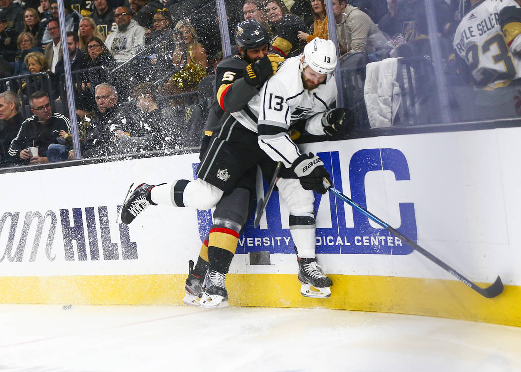 Golden Knights' Deryk Engelland (5) takes Los Angeles Kings' Kyle Clifford (13) to the boards d ...