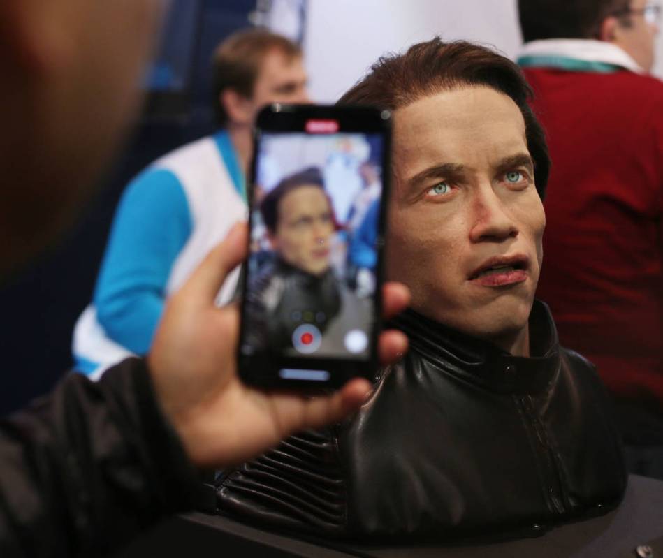 CES attendees video the animatronic bust of Arnold Schwarzenegger introduced by Promobot at the ...