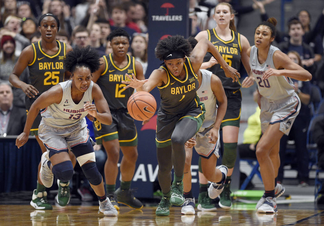 Baylor's NaLyssa Smith, center, grabs takes off with a rebound during the first half of the tea ...