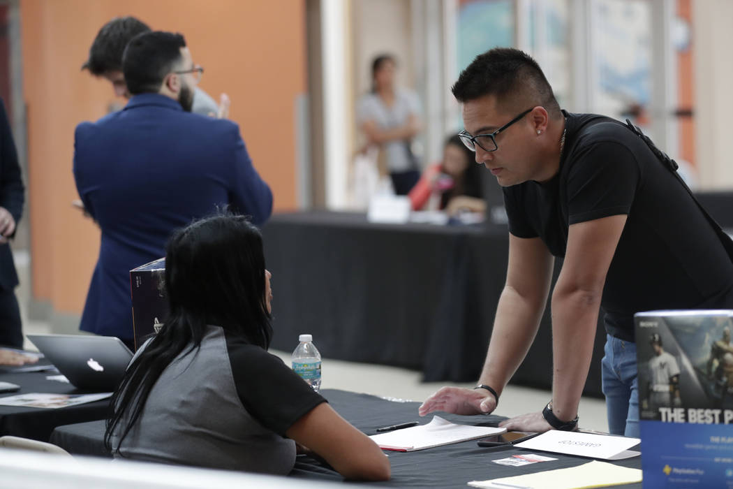 FILE - In this Oct. 1, 2019, file photo, Gabriel Picon, right, talks with a representative from ...