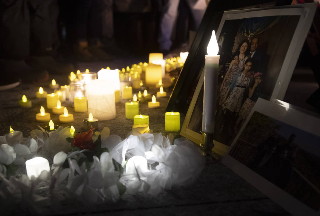 Candles sit in front of pictures of victims at a candle light vigil to remember those killed in ...