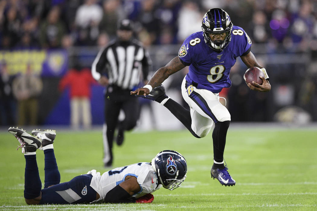 Baltimore Ravens quarterback Lamar Jackson (8) runs past Tennessee Titans cornerback Logan Ryan ...