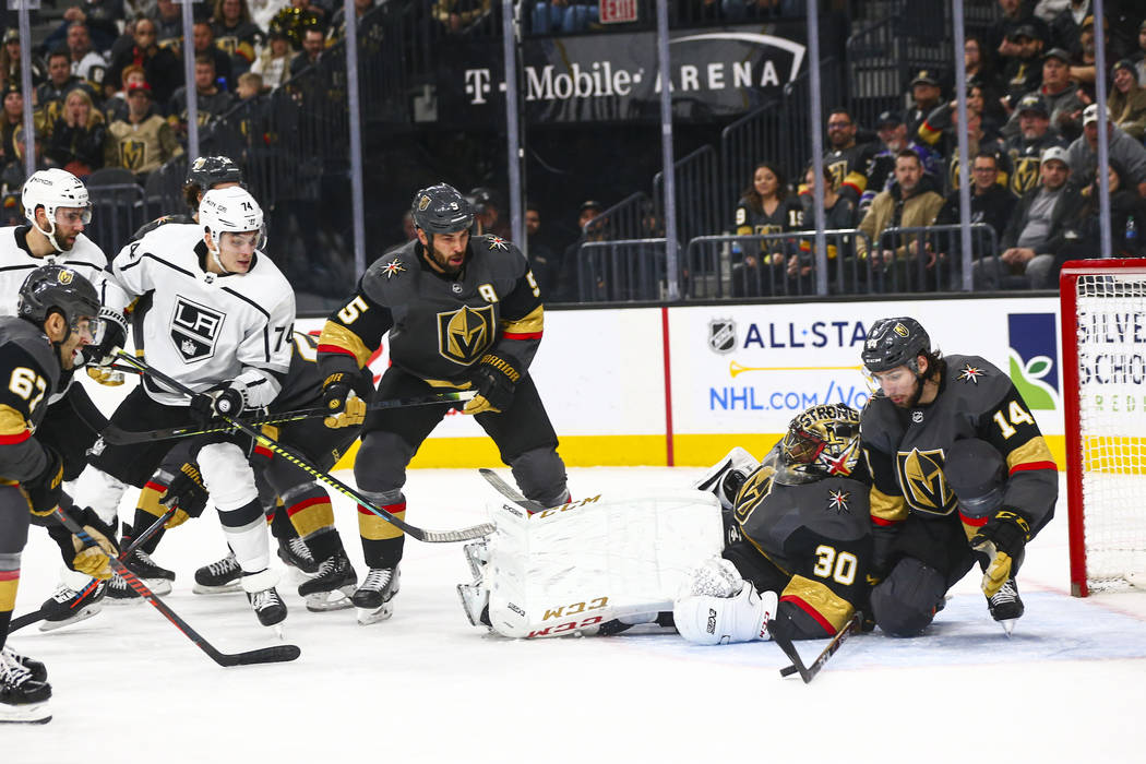 Golden Knights' Nicolas Hague (14) blocks a rebound shot from Los Angeles Kings' Nikolai Prokho ...