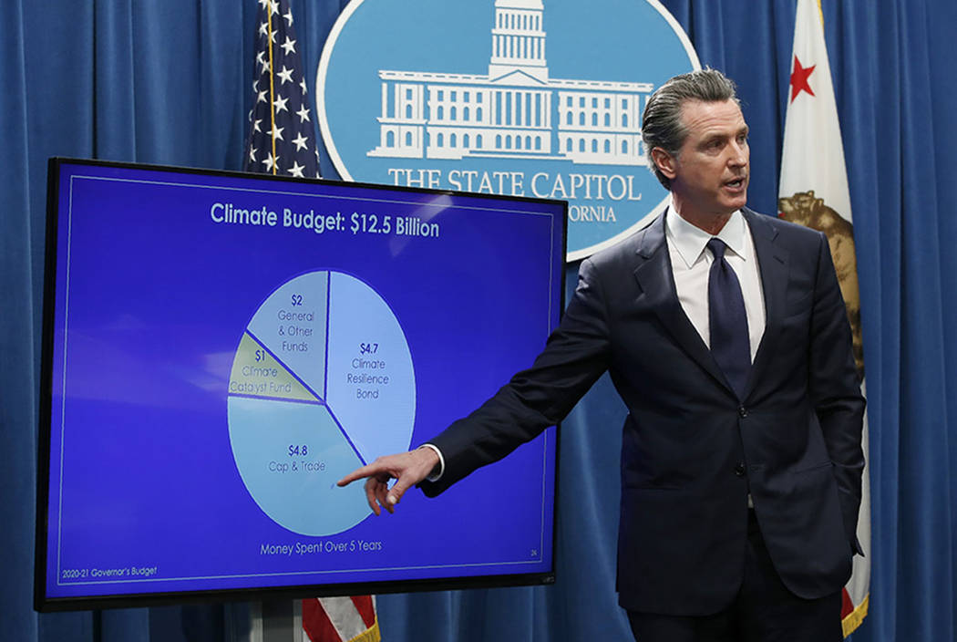 California Gov. Gavin Newsom gestures toward a chart showing funds he has allocated to climate ...