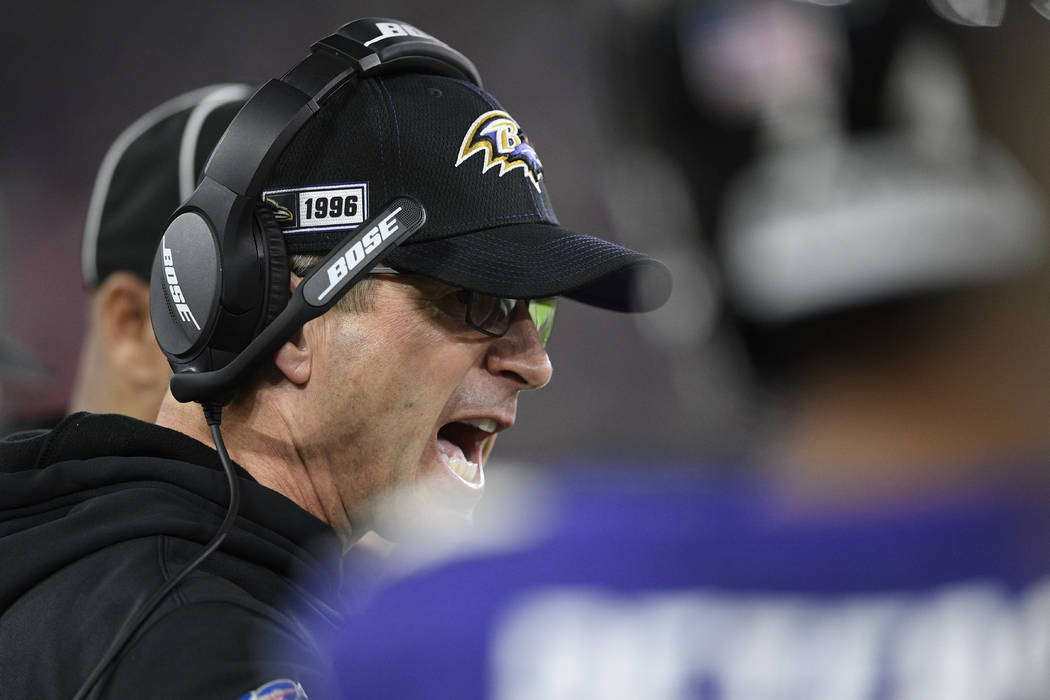 Baltimore Ravens head coach John Harbaugh speaks to players on ther sidelines during the first ...