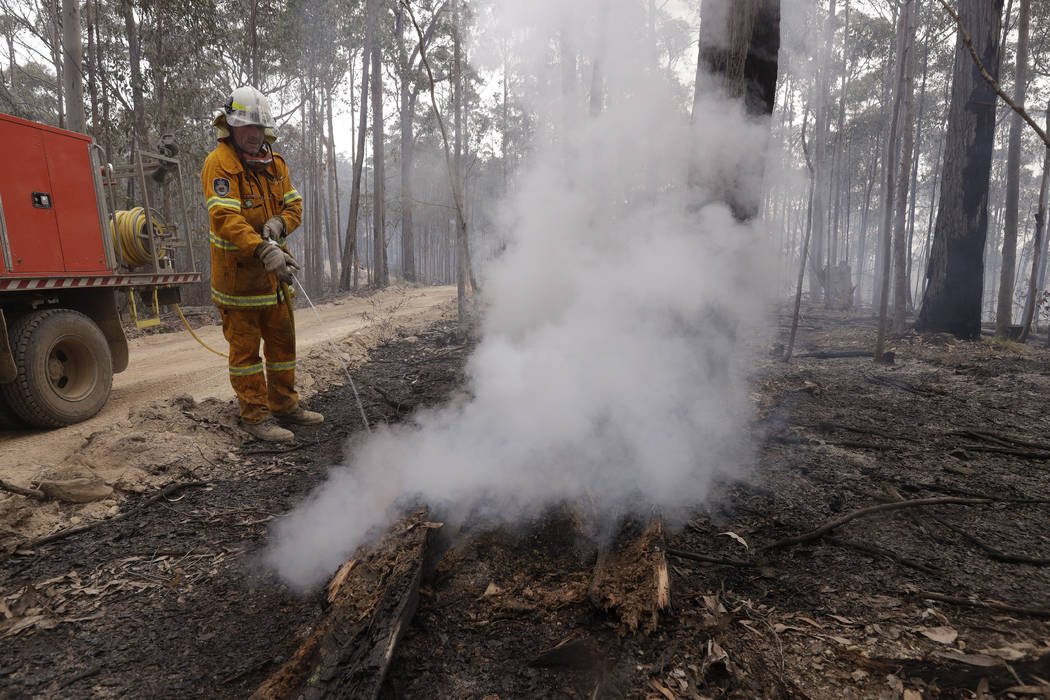 A firefighter patrols a controlled fire as they work at building a containment line at a wildfi ...