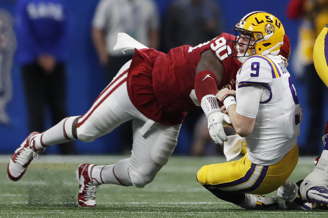 Oklahoma defensive lineman Neville Gallimore (90) tackles LSU quarterback Joe Burrow (9during t ...