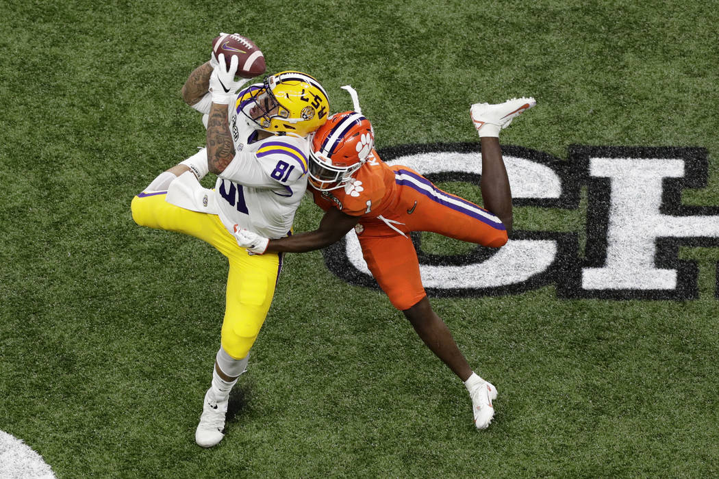 Clemson quarterback Trevor Lawrence passes under pressure from LSU linebacker K'Lavon Chaisson ...