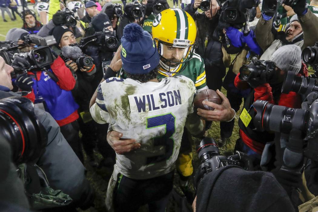 Green Bay Packers' Aaron Rodgers talks to Seattle Seahawks' Russell Wilson after an NFL divisio ...