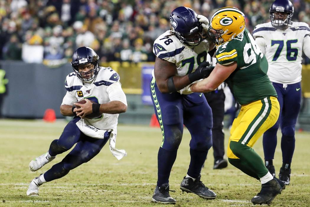 Seattle Seahawks' Russell Wilson runs for a first down during the second half of an NFL divisio ...
