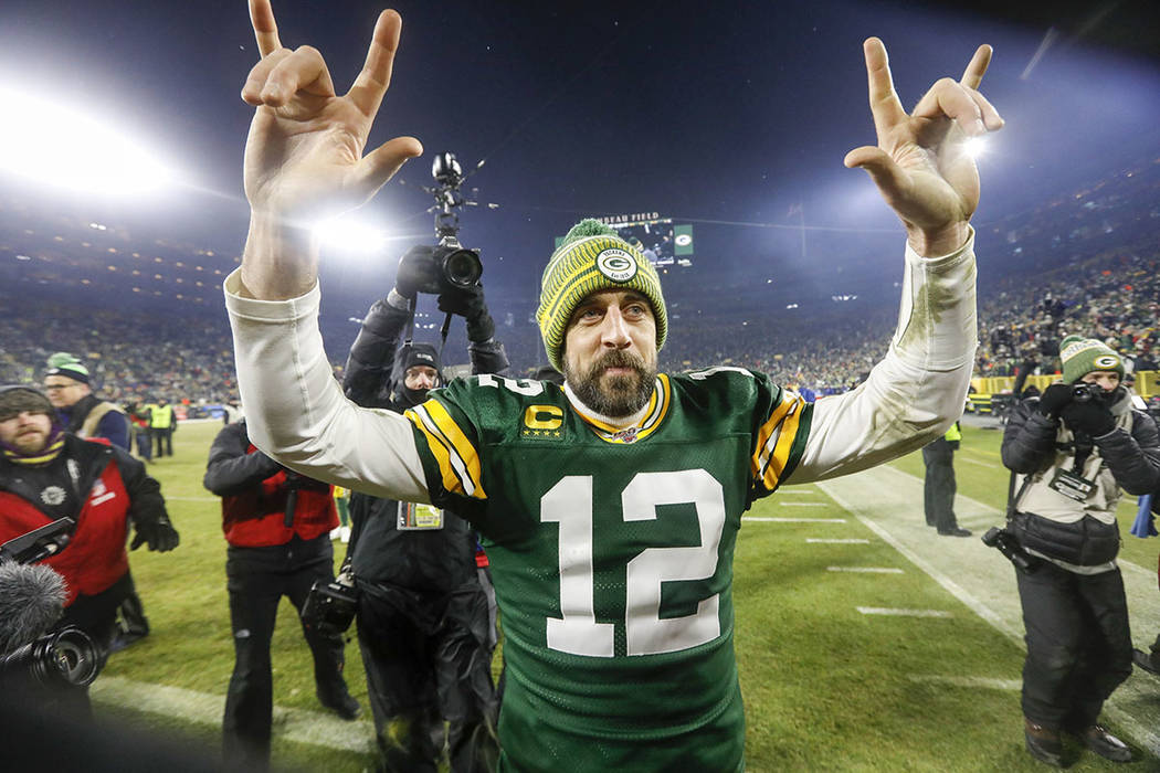 Green Bay Packers' Aaron Rodgers celebrates as he walks off the field after an NFL divisional p ...