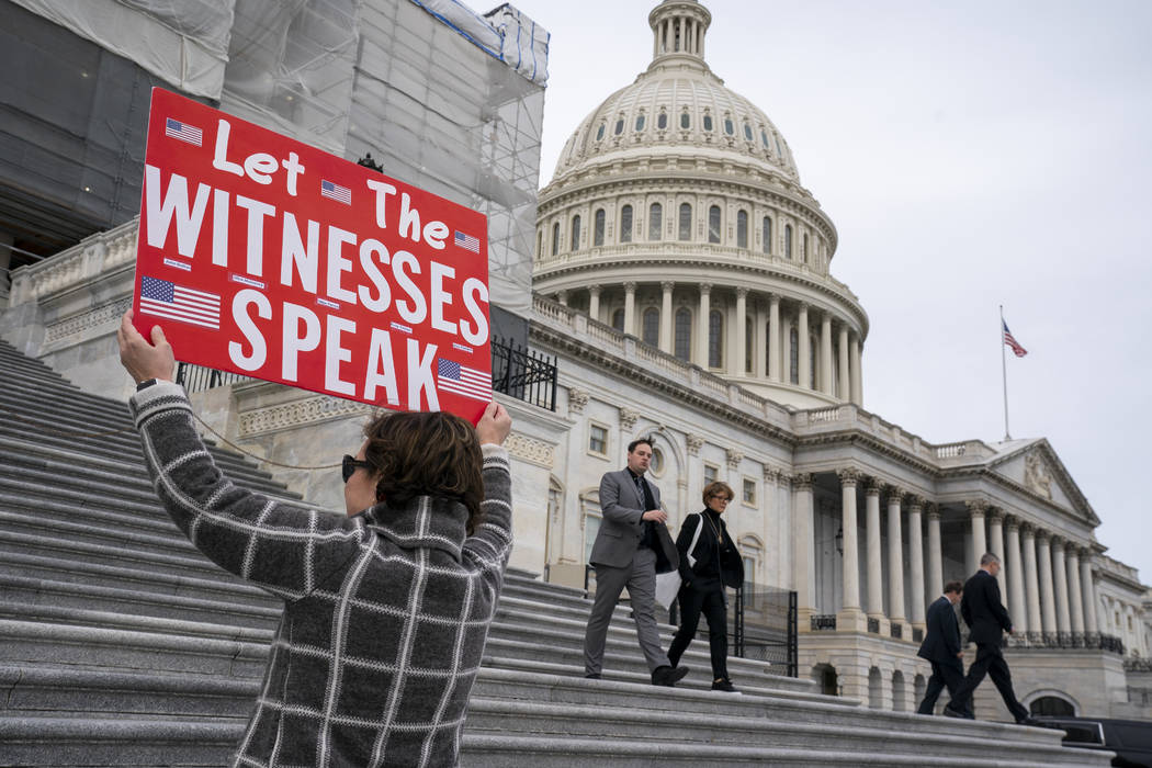 Laura Albinson of Pasadena, Md., displays a message for members of the House as they leave the ...
