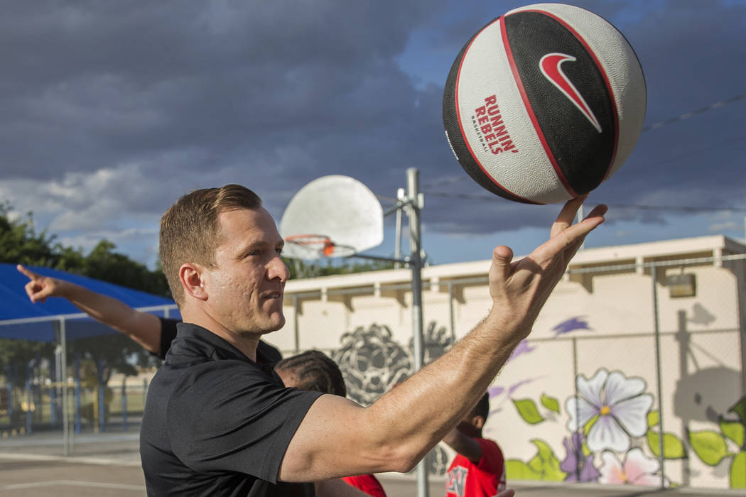 UNLV head basketball coach T.J. Otzelberger spins a basketball on his finger during a youth cli ...