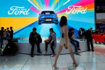 FILE - In this April 25, 2018, file photo, attendees visit the Ford booth during Auto China 201 ...