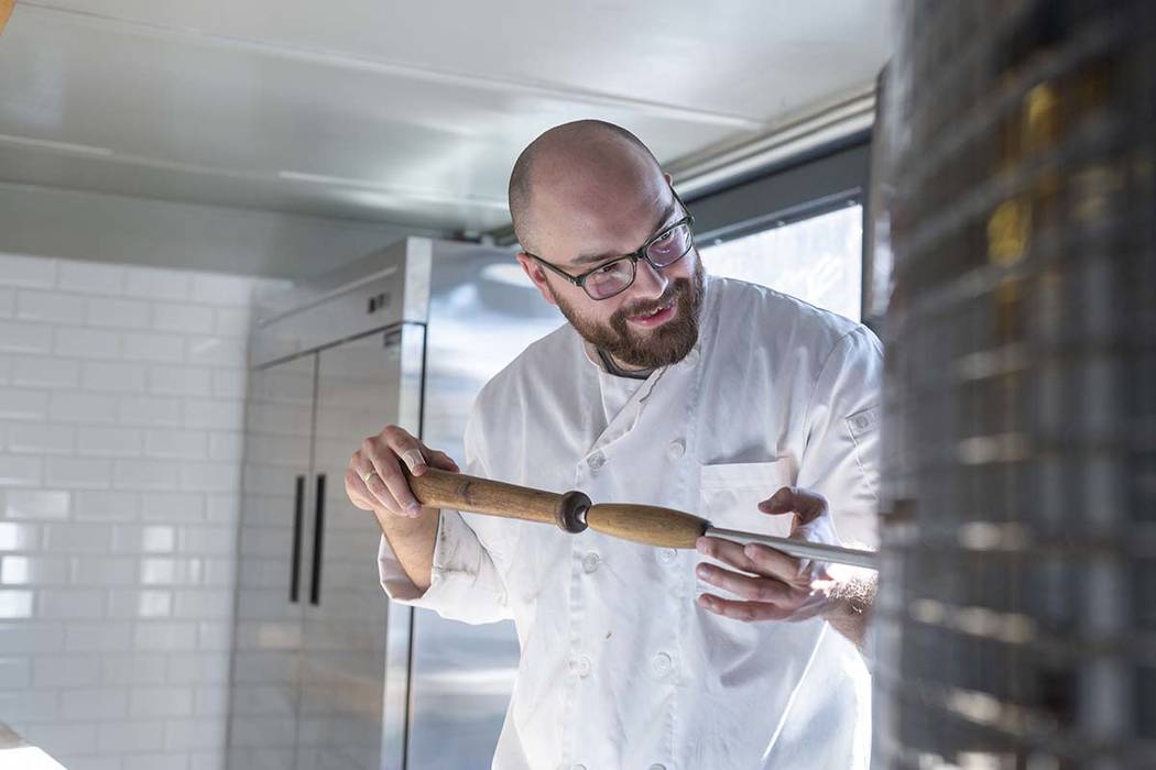 Chef Bartosz Wawrzyszak, owner of the Custom Pizza Truck, makes a pizza in his food truck on Th ...