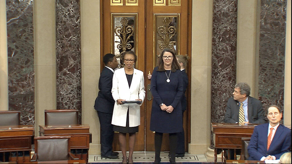 In this image from video, Clerk of the House Cheryl Johnson, left, delivers articles of impeach ...