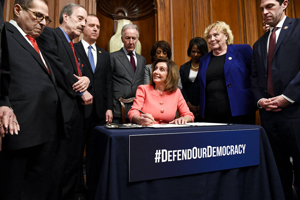 Speaker of the House Nancy Pelosi, D-Calif., signs the articles of impeachment during an engros ...