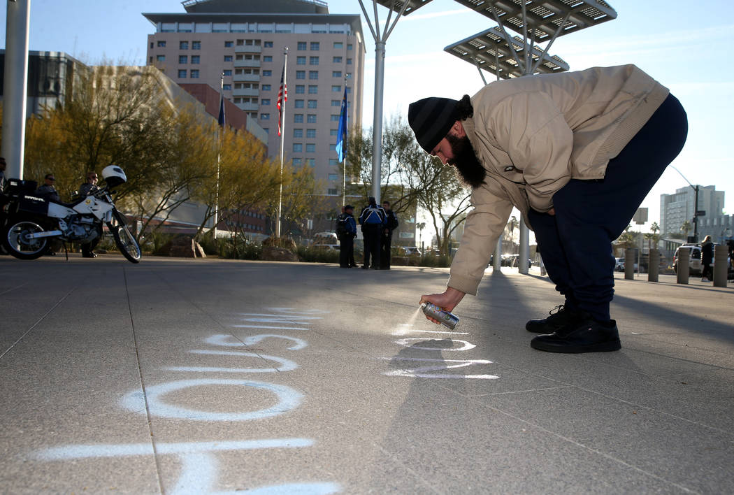 Joey Lankowski of Las Vegas uses sidewalk chalk spray before the start of a Las Vegas City Coun ...