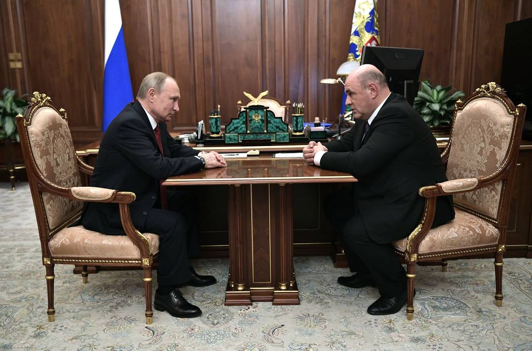 Russian President Vladimir Putin, left, listens to Tax Service chief Mikhail Mishustin during t ...