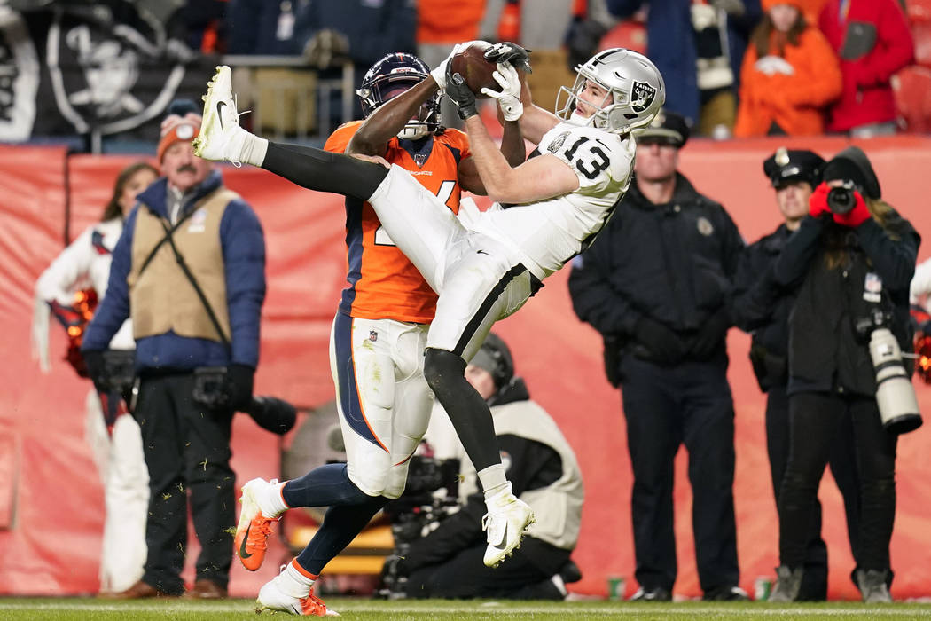 Oakland Raiders wide receiver Hunter Renfrow (13) hauls in a pass as Denver Broncos cornerback ...