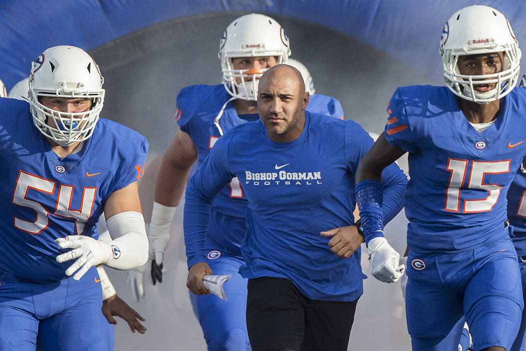 Bishop Gorman head coach Kenny Sanchez, middle, leads the Gaels onto the field before the start ...