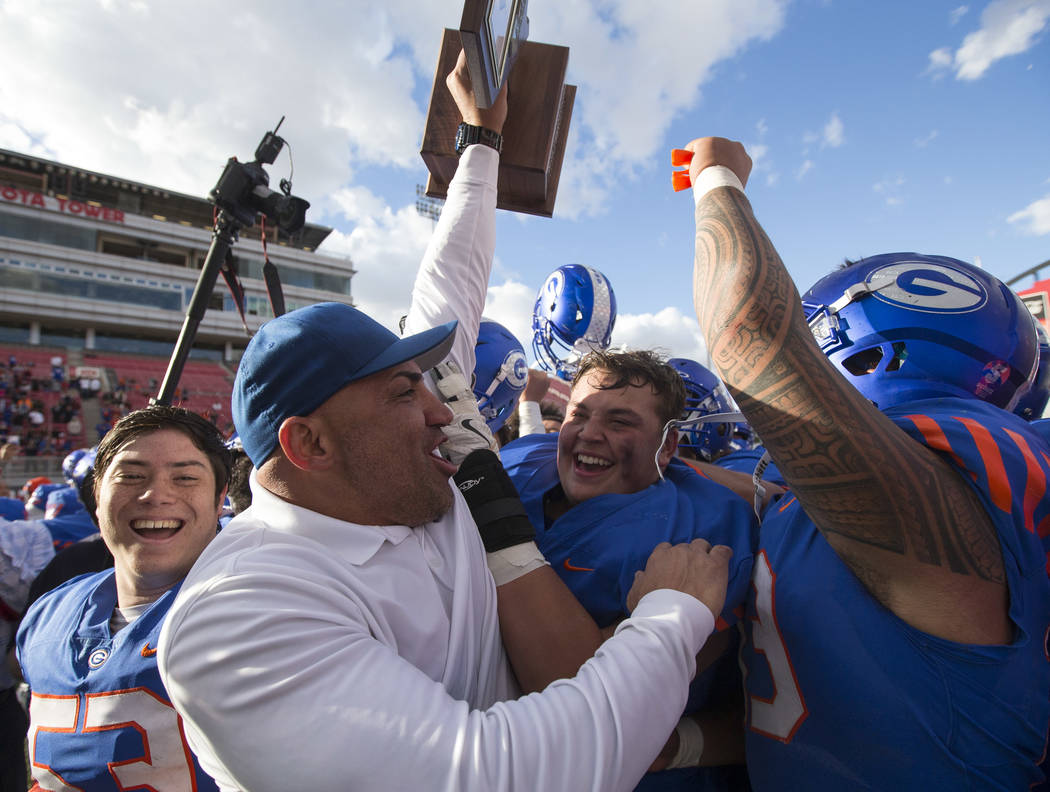 Bishop Gorman coach Kenny Sanchez and his players celebrate after defeating Reno's Bishop Manog ...