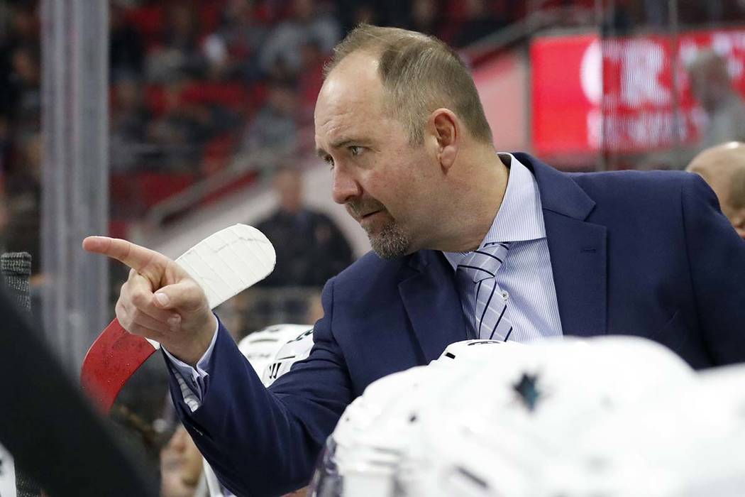 San Jose Sharks' head coach Peter DeBoer confers with an official during an NHL hockey game aga ...