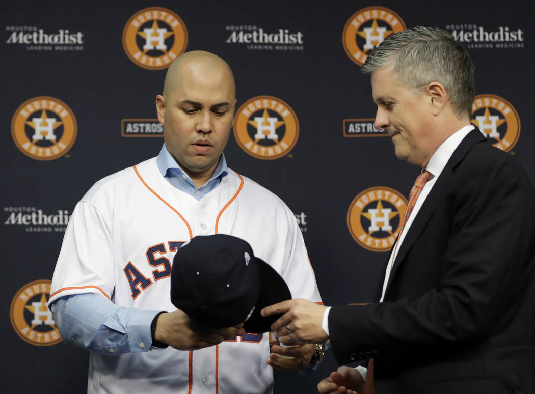 FILE - In this Dec. 5, 2016, file photo, Houston Astros general manager Jeff Luhnow, right, han ...