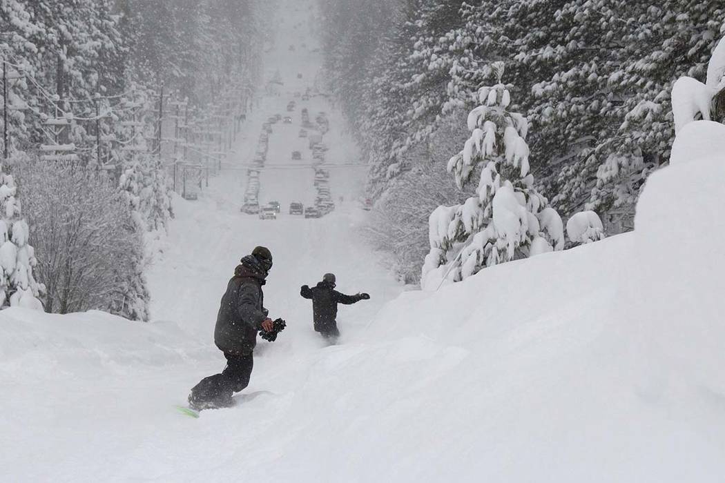 Two men snowboard down a steep street in South Lake Tahoe, Calif., Friday, Feb. 15, 2019. (Ryan ...