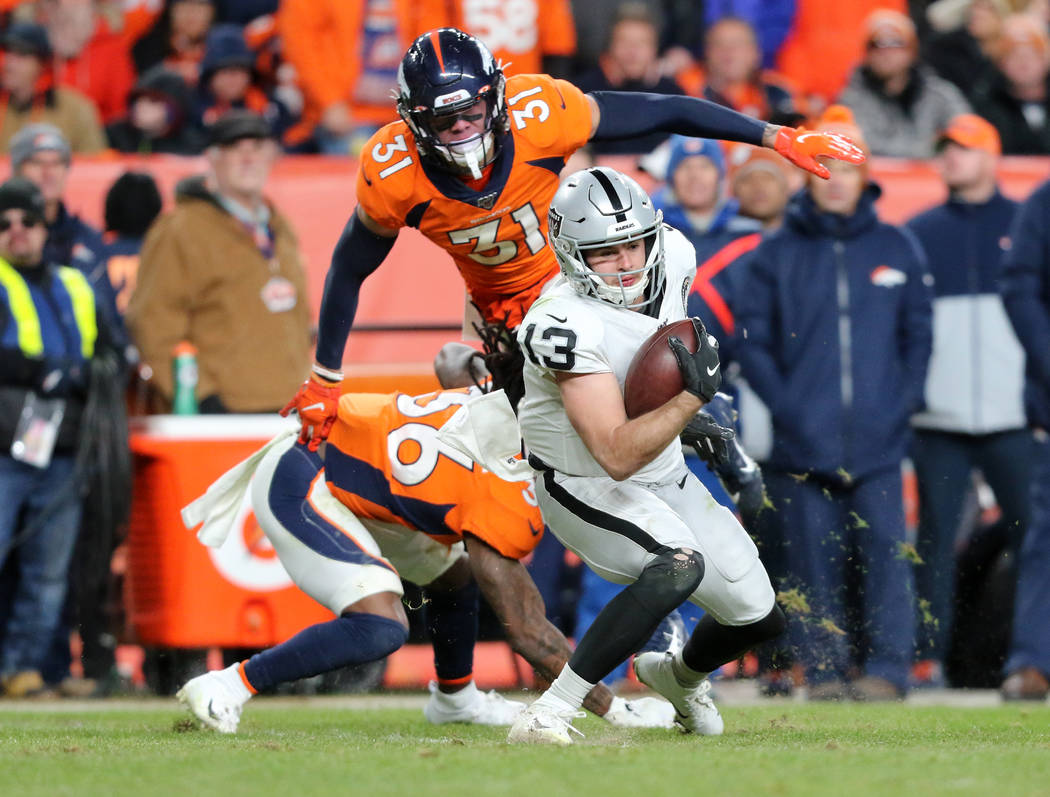 Oakland Raiders wide receiver Hunter Renfrow (13) catches the football as Denver Broncos defens ...