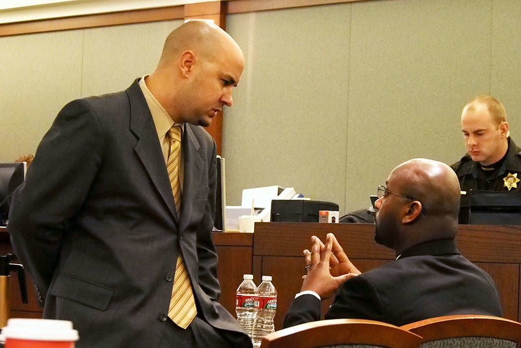 Attorney Jack Buchanan, left, talks with his client Benjamin Hawkins, right, during a recess at ...